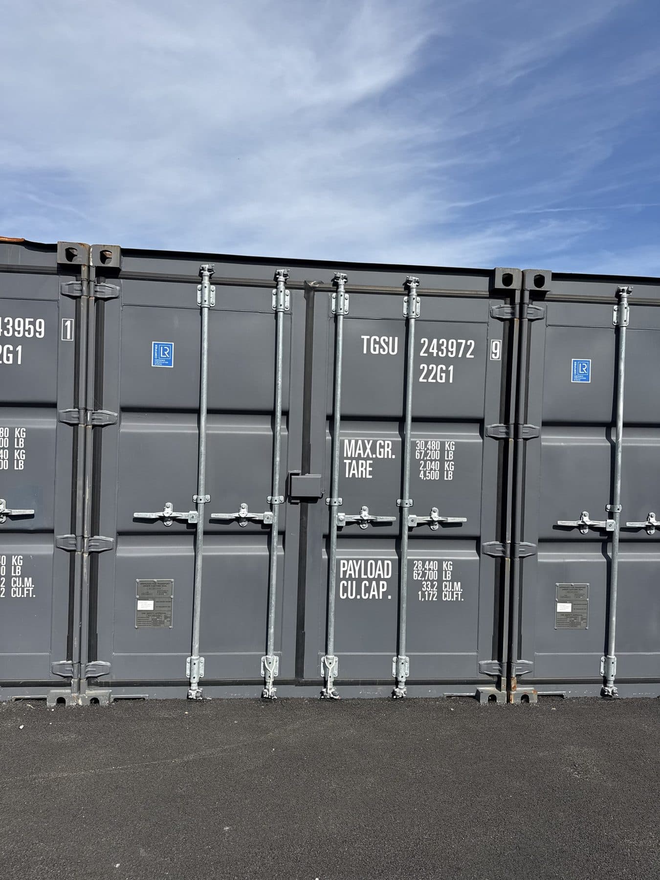 Conteneurs vus de face, portes fermées le long de l’allée