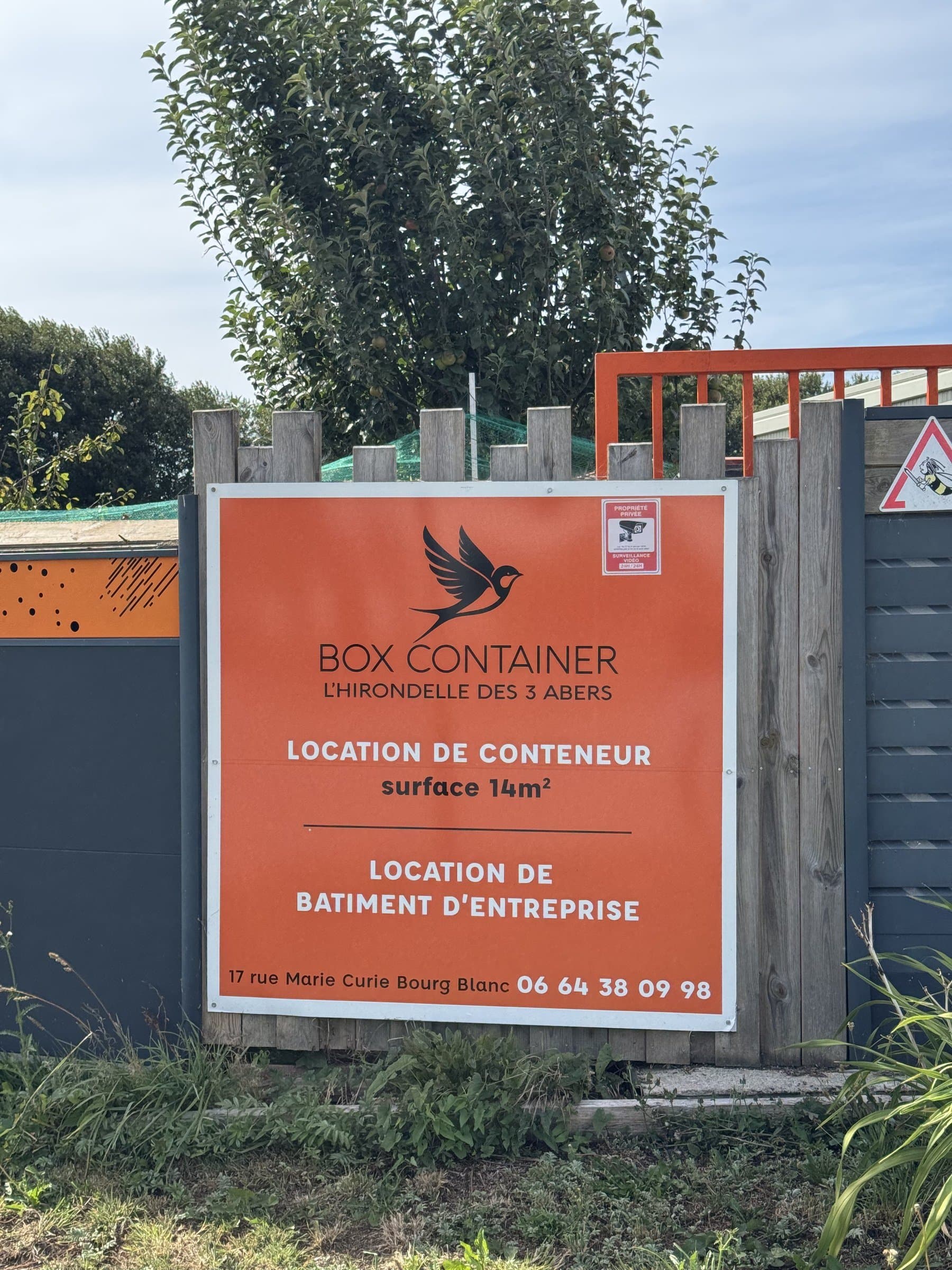 Panneau BOX CONTAINER sur la clôture, avec l’avis de vidéosurveillance 24 h/24